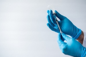 health care worker putting on gloves